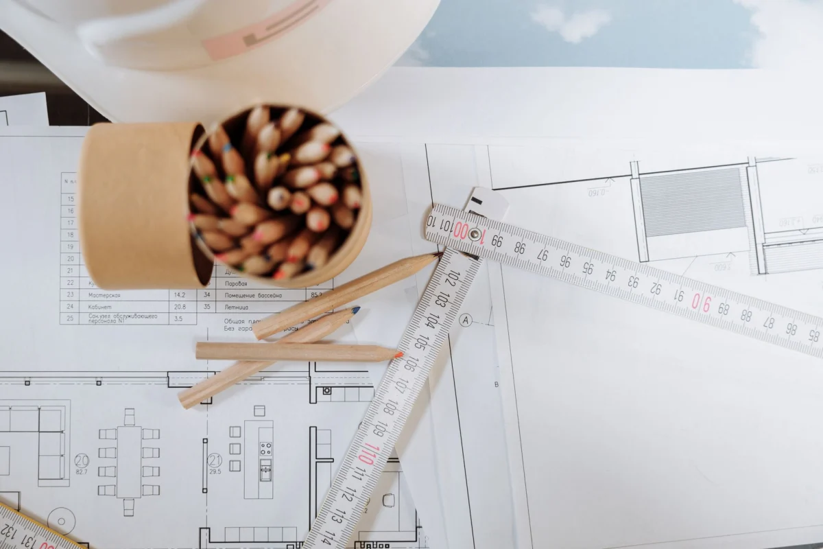 Plans de rénovation et mètre ruban posés sur une table de travail